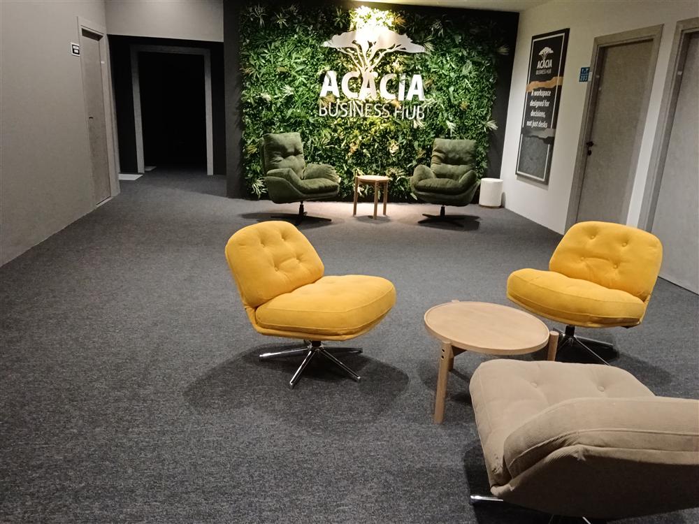 Lounge seating in mustard and sage beside the living wall