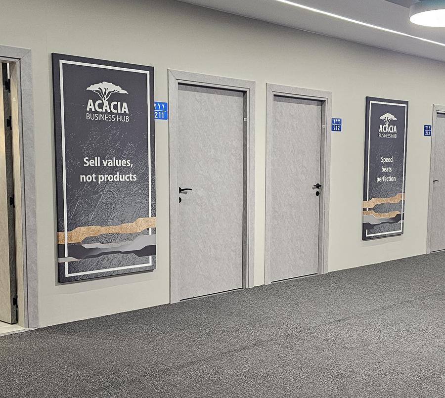 Close view of an ACACIA brand panel and numbered office doors — the address your company registers at